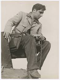 Robert Capa holding his 35mm Contax on a Japanese tank captured at the Battle of Taierzhuang, Xuzhou Front, China, April 1938. Photographer unknown.