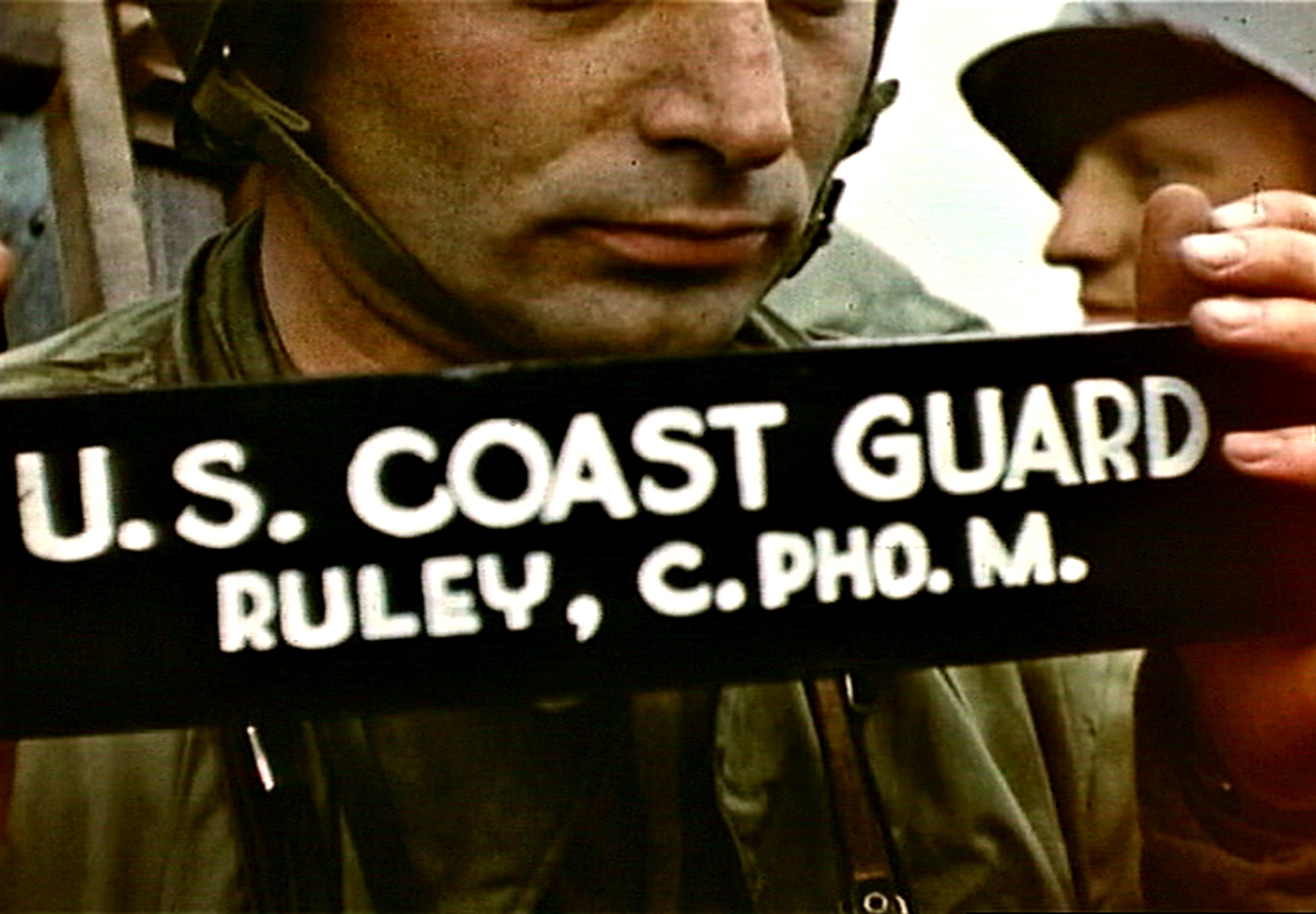 Fig. 10: Robert Capa holding cinematographer's slate aboard LCI(L)-94, D-Day, frame from film by David T. Ruley