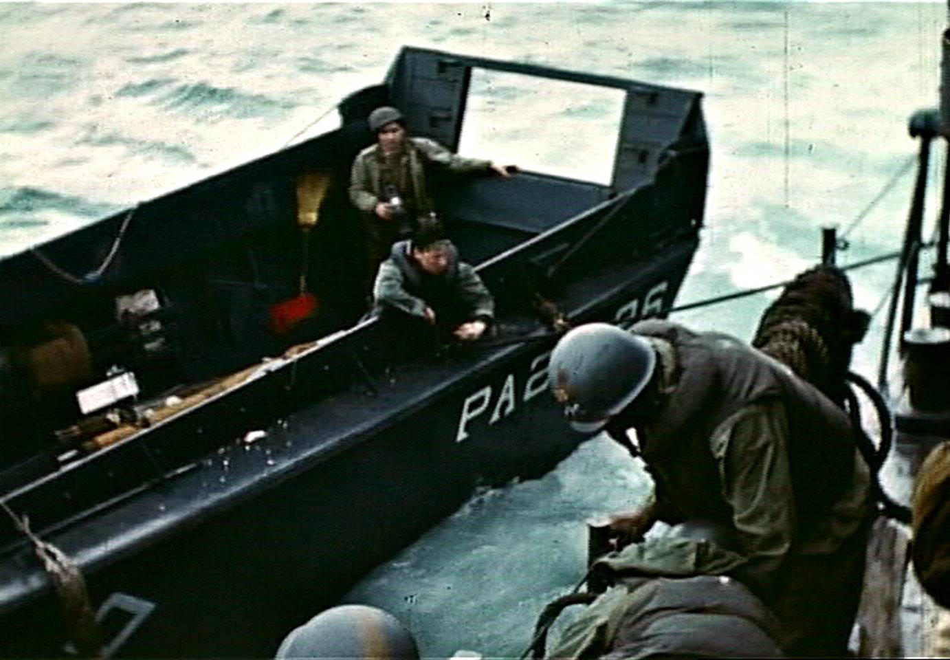 Fig. 12: Robert Capa, center rear, aboard LCVP from USS Samuel Chase, photographing transfer of casualty, D-Day, frame from film by David T. Ruley