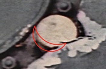 Figure 10. This image is an enlarged detail from Figure 7. The highlighted shadow line indicates an irregular rim projecting beyond the diameter of the rest of the object, consistent with a soft wood that "mushroomed" as a result of being hammered.